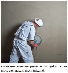 Zacieranie końcowe powierzchni tynku za pomocą zacieraczki mechanicznej.